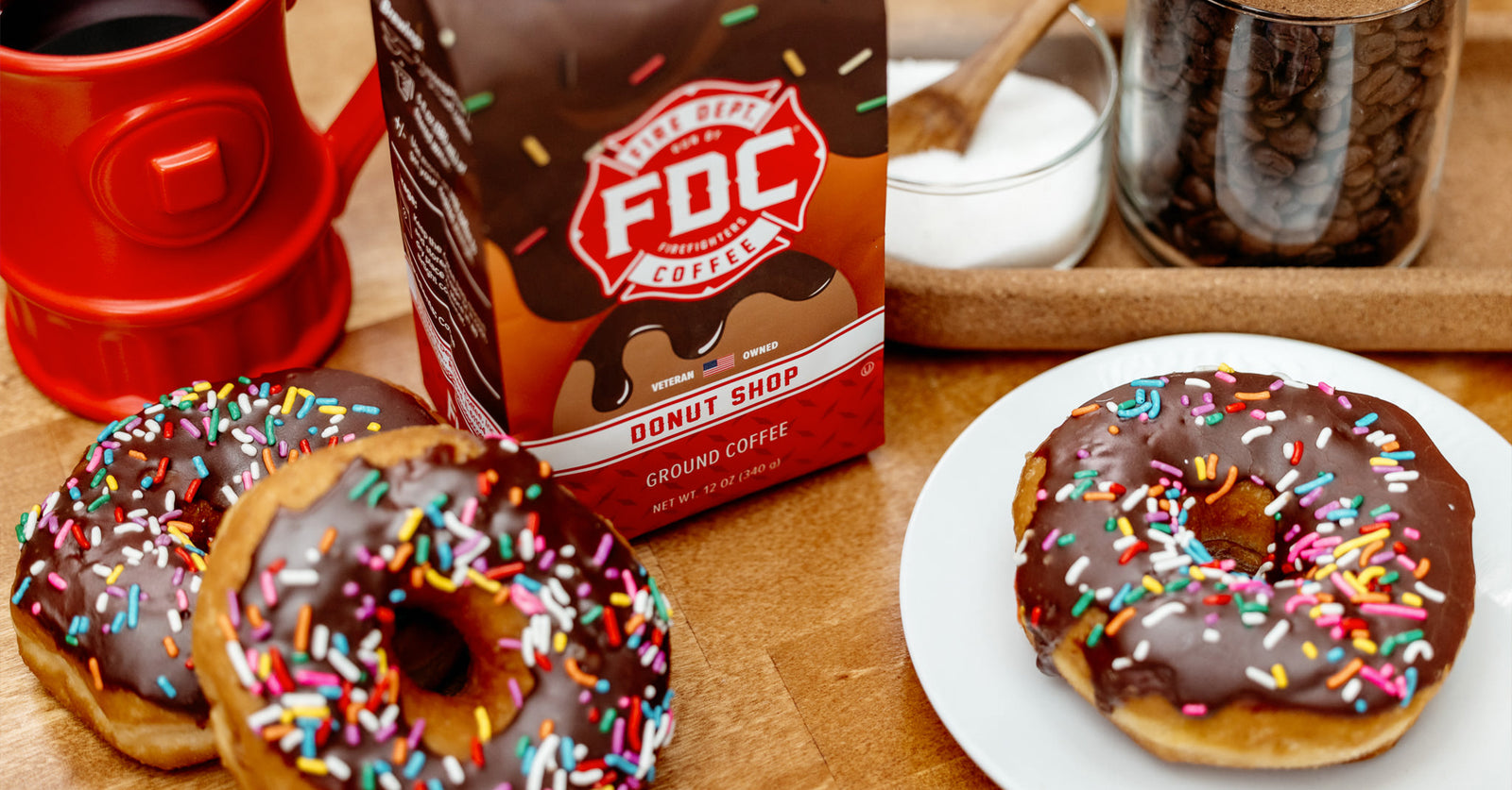 A downward image of Donut Shop Coffee and chocolate donuts with sprinkles.