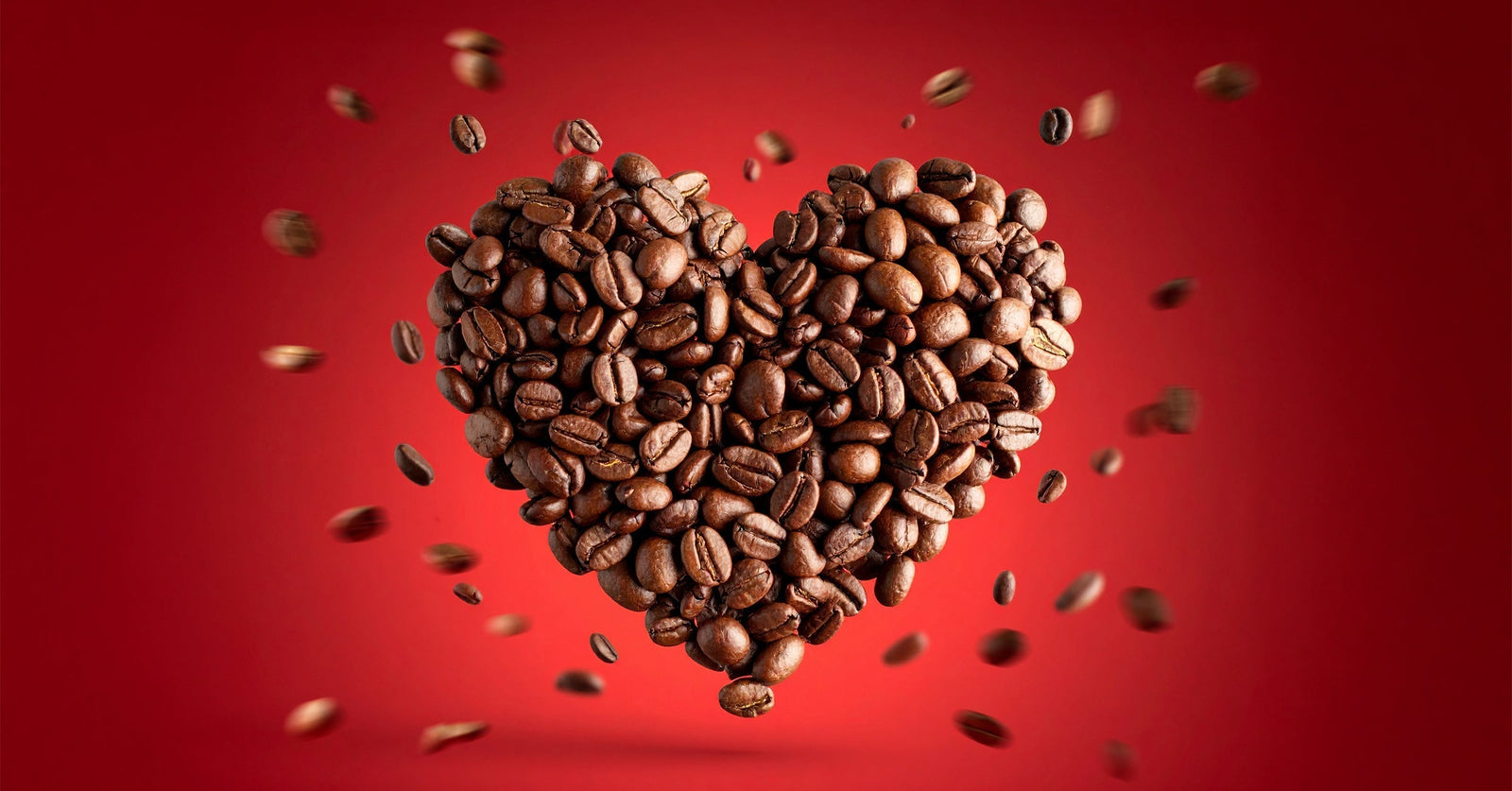A heart made of coffee beans on a read background.
