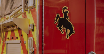 A graphic of a cowboy riding a wild horse on the back of a Laramie Fire Department fire truck.