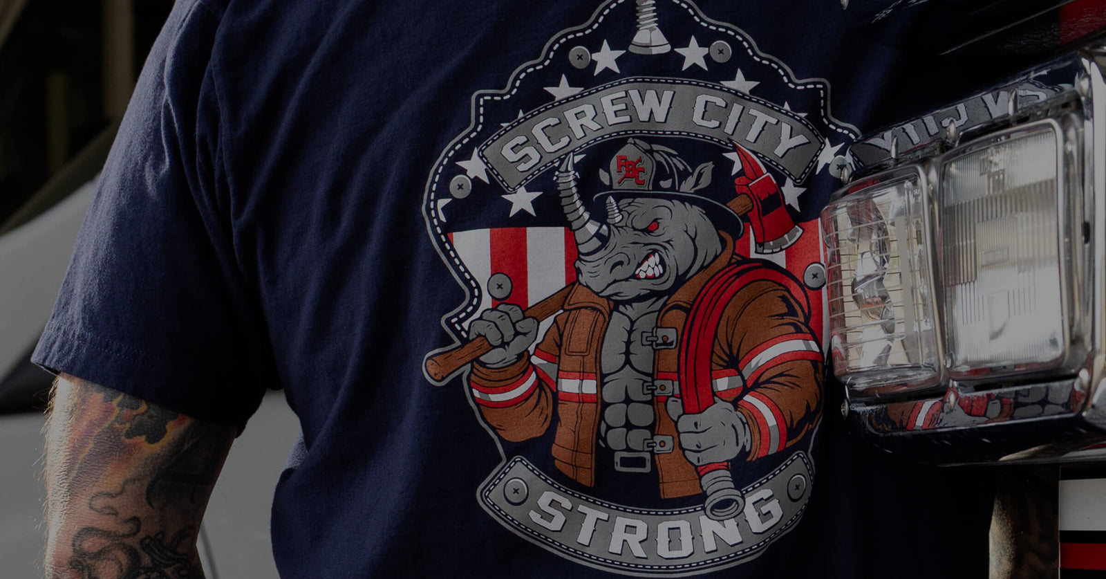 Firefighter rhino design on the back of a navy blue shirt paired with the words "Screw City Strong."