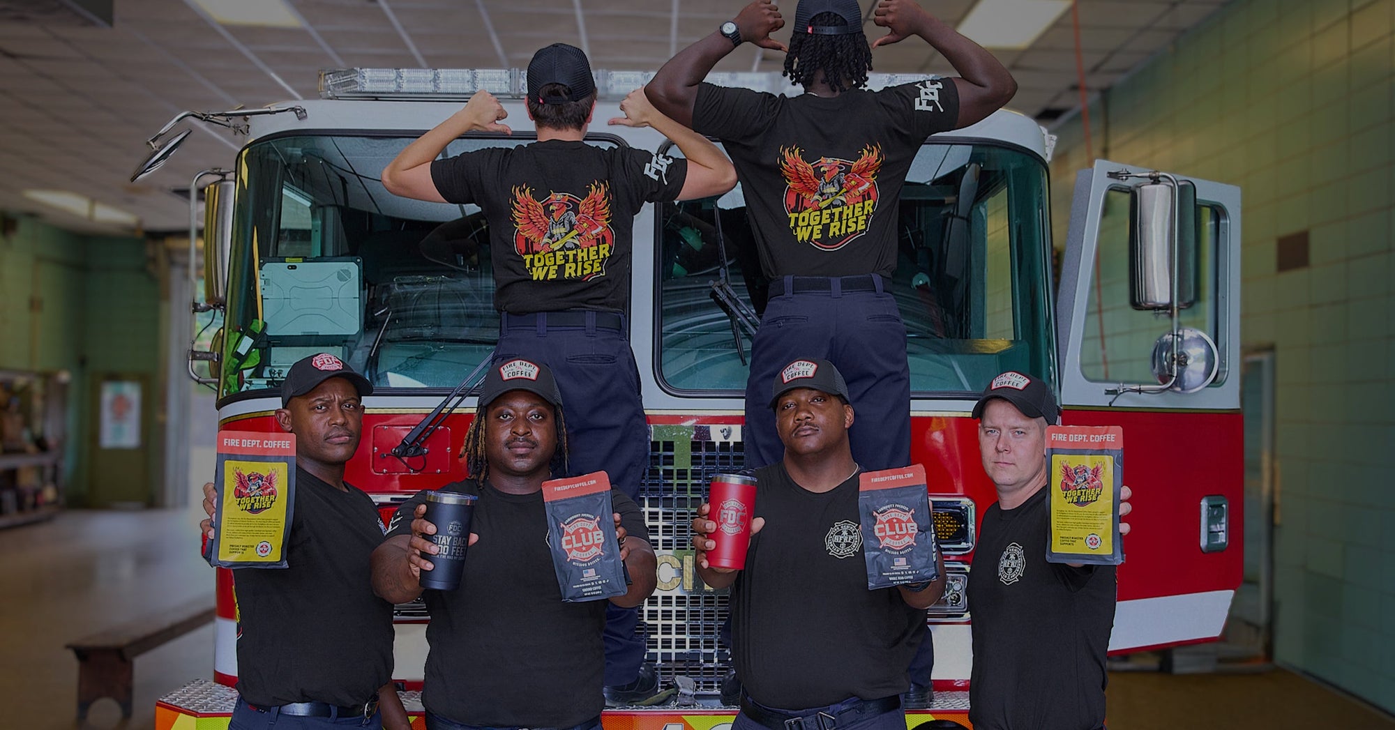 Atlanta firefighters standing in front of a fire truck inside of a fire station.