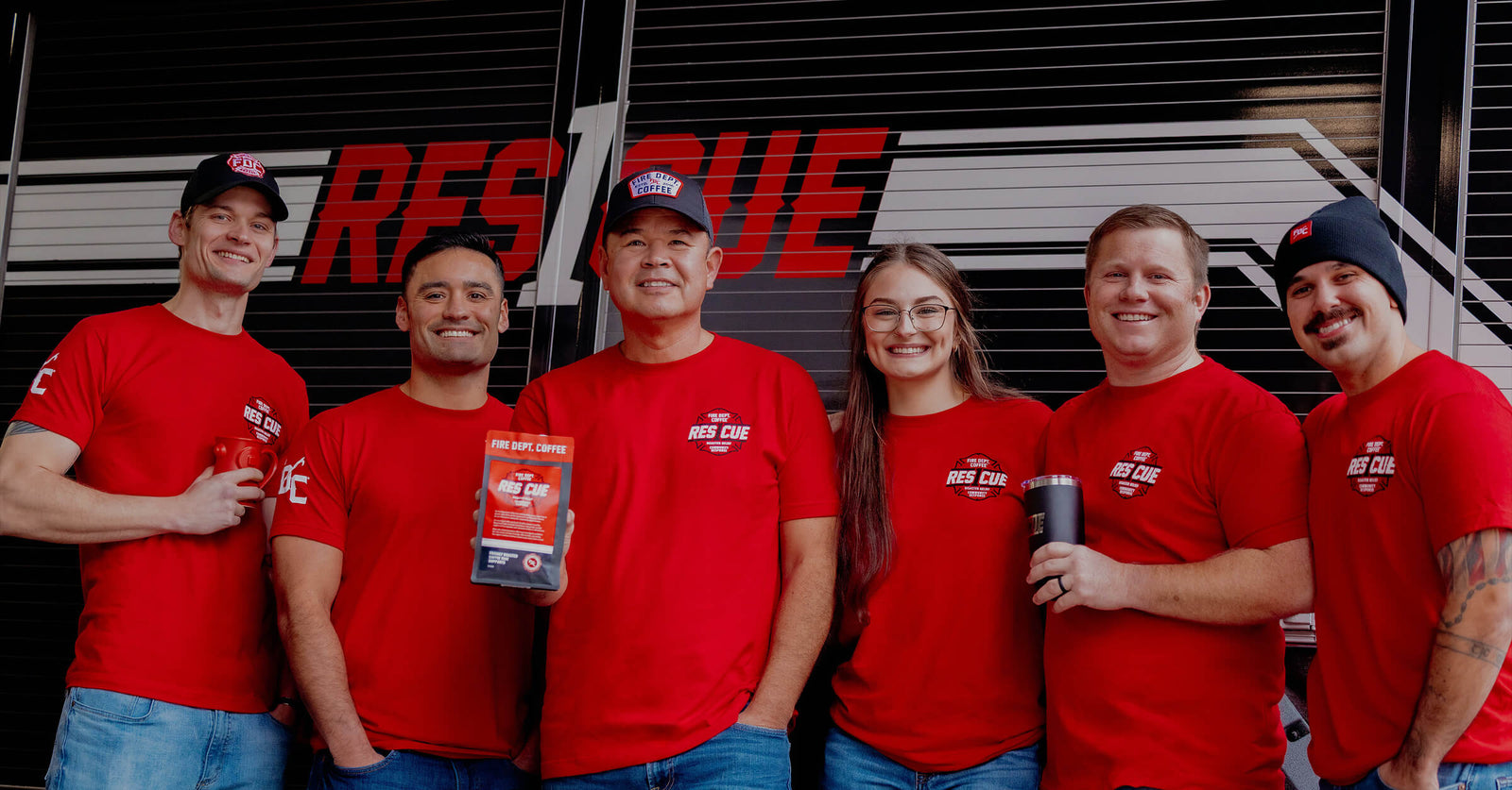 Group of firefighters standing together in front of the Rescue 1 fire truck.
