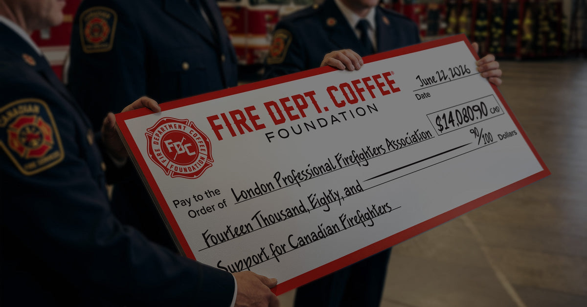 Close up of Canadian firefighters holding an oversized donation check presented by the Fire Department Coffee Foundation.
