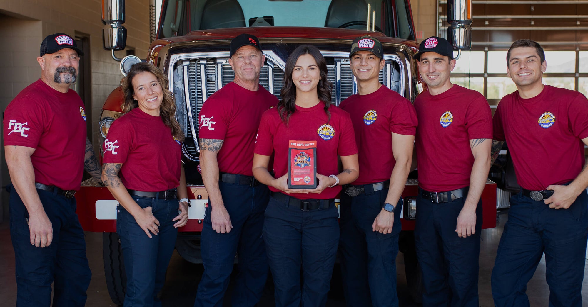 Group of firefighters standing in front of a fire truck.