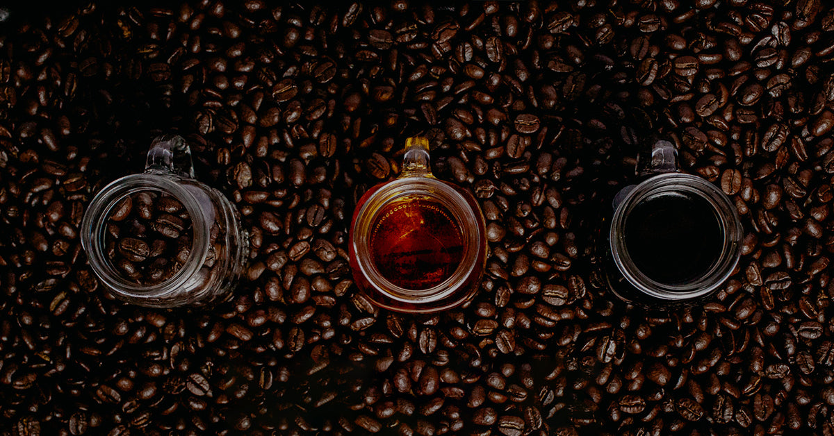 Spirits and Coffee in glass jars sitting on top of a spread of coffee beans