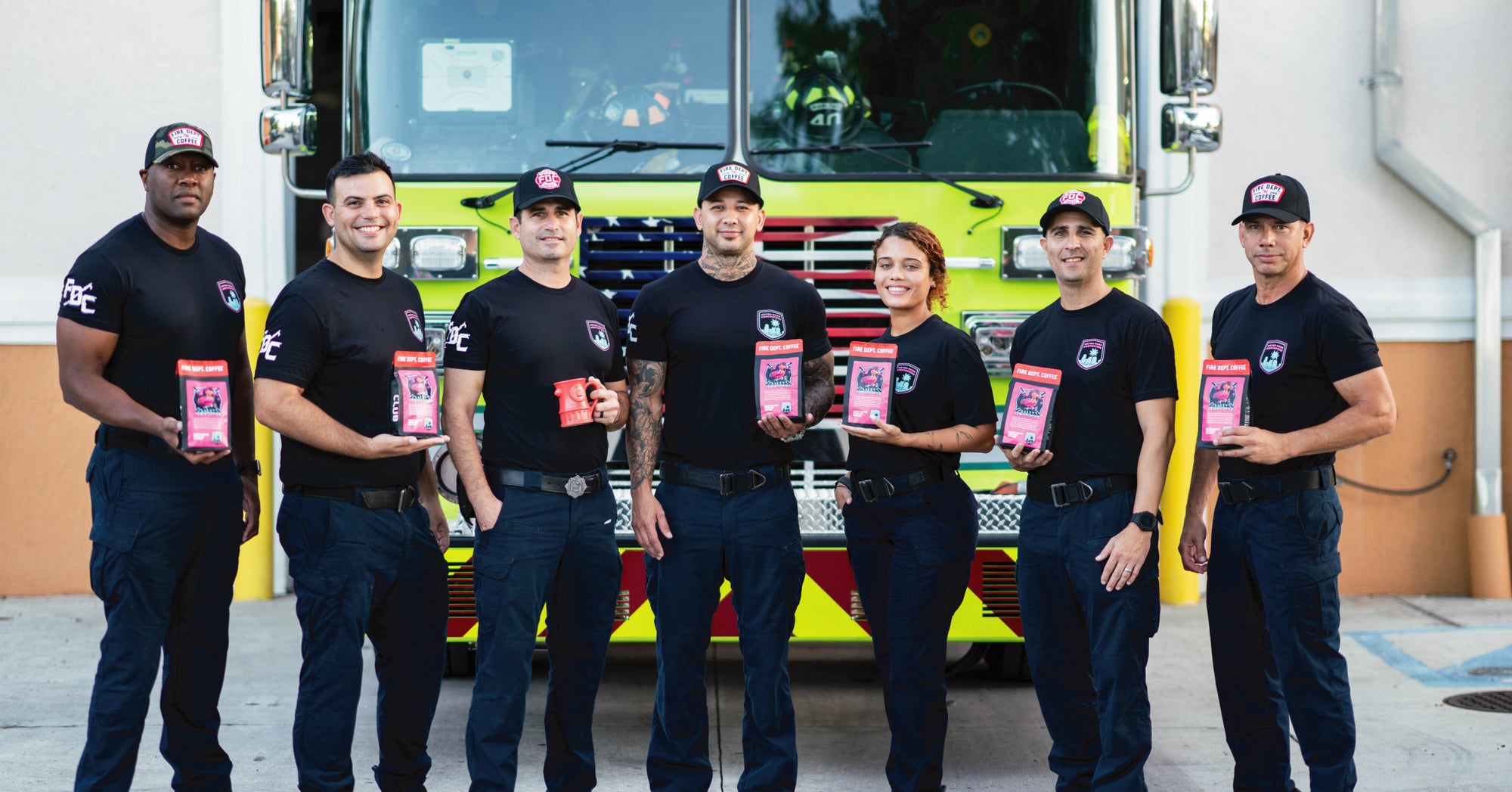 Group shot of Miami firefighters holding coffee and wearing shirts from Fire Department Coffee.