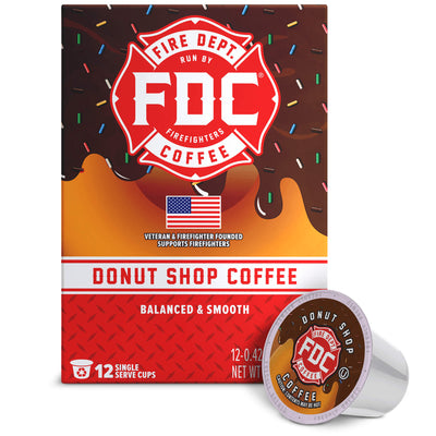 A box of FDC Fire Department Coffee Donut Shop Coffee with a single single-serve coffee pod placed in front on a white background.