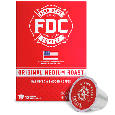 A red box of FDC Fire Department Coffee Single Serve K-Cups with one single-serve coffee capsule placed in front on a white background.