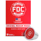 A red box of FDC Fire Department Coffee Single Serve K-Cups with one single-serve coffee capsule placed in front on a white background.