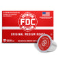 A red box of FDC Fire Department Coffee Original Medium Roast coffee capsules, shown with one silver and red single-serve coffee capsule in front on a white background.