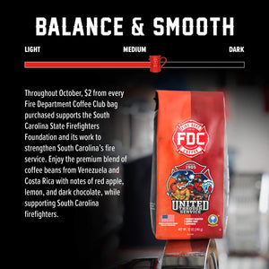 A 12 oz bag of FDC Fire Department Coffee on a white background with a black banner at the bottom reading 'GIVES BACK TO SUPPORT'. The bag is orange and red with a prominent red FDC logo and a 'United Through Service' firefighter illustration.