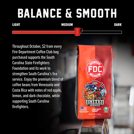 A bag of Fire Department Coffee Club United Services coffee stands on a reflective surface against a dark background with a large ’BALANCE & SMOOTH’ graphic and a progress bar. Text on the left explains that $2 from each bag purchased supports the South Carolina State Firefighters Foundation.