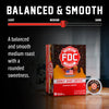 A box of FDC Fire Department Coffee Donut Shop Coffee in the Balanced & Smooth medium roast variety, shown alongside a single coffee capsule on a dark background with marketing text and a roast slider graphic.