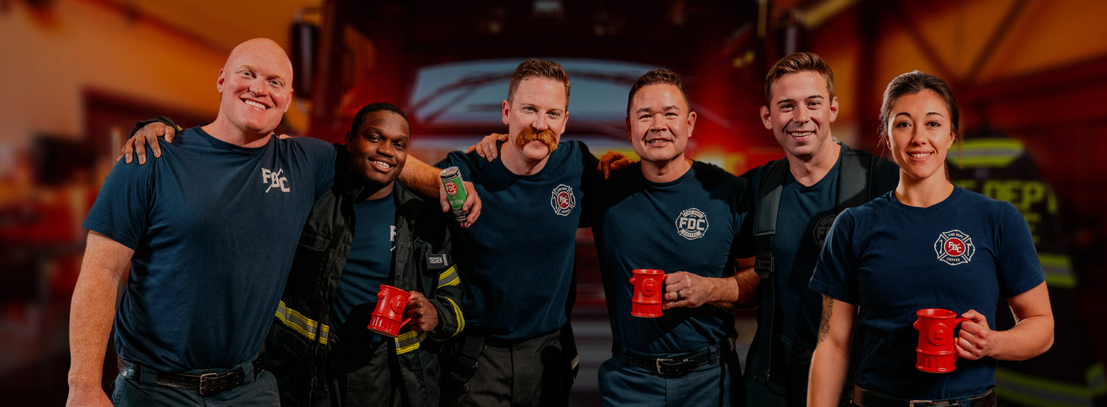 A group of firefighters smiling and holding coffee mugs.