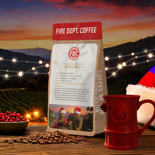Fire Dept. Coffee package with a red mug, coffee beans, and Christmas decorations against a sunset backdrop.