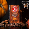FDC Pumpkin Rum coffee packaging with pumpkins, cinnamon sticks, and a bottle in the background.

