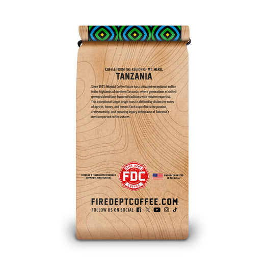 A single stand-up coffee bag with a wood-grain style print and a colorful geometric pattern around the rolled top, shown on a plain white background. Visible text includes ’Coffee from the Region of Mt.