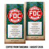 Two bags of FDC Fire Department Coffee from Tanzania displayed side by side on a white background with a black text banner at the bottom reading 'COFFEE FROM TANZANIA | AUGUST 2026'. The bags feature a light wood grain texture with a colorful geometric pattern in blue, green, and yellow, and a prominent red and white FDC logo.