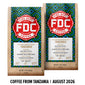 Two bags of FDC Fire Department Coffee from Tanzania displayed side by side on a white background with a black text banner at the bottom reading ’COFFEE FROM TANZANIA | AUGUST 2026’. The bags feature a light wood grain texture with a colorful geometric pattern in blue, green, and yellow, and a prominent red and white FDC logo.