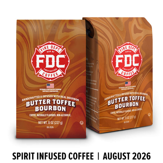 Two bags of FDC Fire Department Approved Coffee in the Butter Toffee Bourbon flavor, shown on a white background with a black text banner at the bottom reading ’SPIRIT INFUSED COFFEE | AUGUST 2026’.