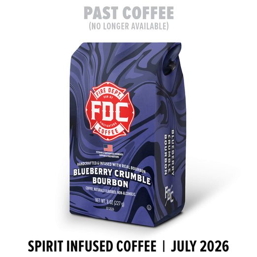 A bag of FDC Fire Department Coffee Blueberry Crumble Bourbon in a dark blue marbled pattern, with a red and white Fire Department logo. Text above says ’PAST COFFEE (NO LONGER AVAILABLE)’ and text below says ’SPIRIT INFUSED COFFEE | JULY 2026’.