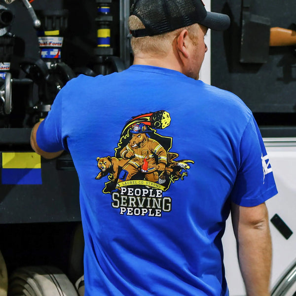 Blue t-shirt with a graphic design and text on the back, displayed on a white background.