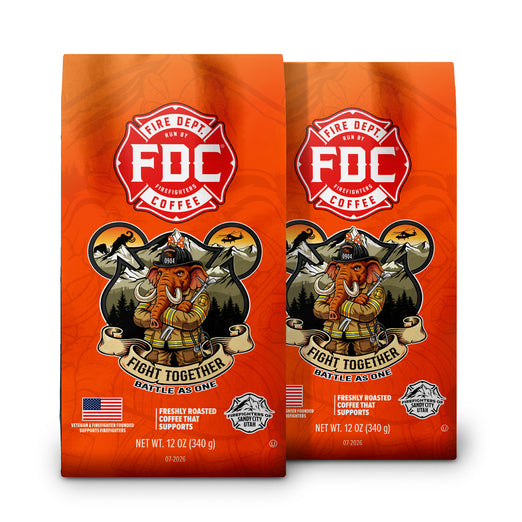 Two bags of FDC Fire Department Coffee on a plain white background. The bags are bright orange with a red and white FDC logo and an illustration of an elephant dressed as a firefighter.