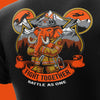 Close-up of a black T-shirt featuring a large firefighter-themed graphic with an orange elephant in a helmet, mountains, trees, and the text 'FIGHT TOGETHER BATTLE AS ONE'.
