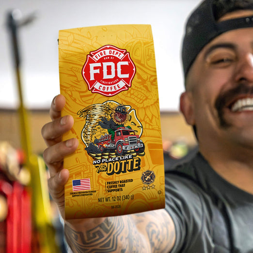 Person holding a yellow FDC Coffee bag with a graphic design and text.