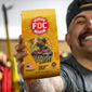 Person holding a yellow FDC Coffee bag with a graphic design and text.