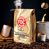 FDC Coffee Toasted Marshmallow Whiskey packaging with marshmallows, coffee beans, and a lit candle on a dark background.