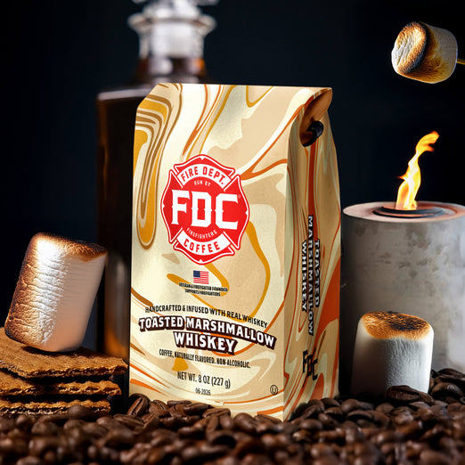 FDC Coffee Toasted Marshmallow Whiskey packaging with marshmallows, coffee beans, and a lit candle on a dark background.