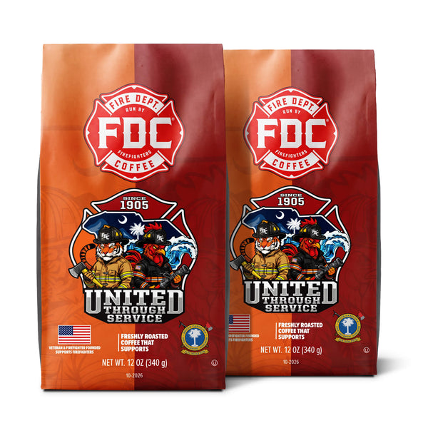 A 12 oz bag of FDC Fire Department Coffee on a white background with a black banner at the bottom reading 'GIVES BACK TO SUPPORT'. The bag is orange and red with a prominent red FDC logo and a 'United Through Service' firefighter illustration.