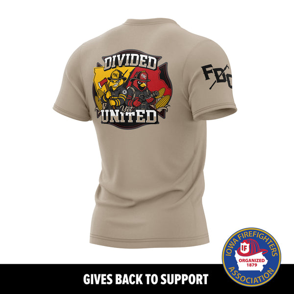 A tan short-sleeve T-shirt shown from the back on a white background, with a large firefighter-themed graphic reading 'DIVIDED YET UNITED' and a fire department badge on the back, plus a printed black FDC Pike Pole logo on the right sleeve. A black banner at the bottom reads 'GIVES BACK TO SUPPORT' and includes the Iowa Firefighters Association logo.