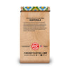A vertical bag of Fire Dept Coffee from Guatemala, featuring a light brown wood-grain patterned design with black text and a colorful patterned ribbon at the top.