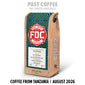 A bag of FDC Coffee from Tanzania stands upright on a white background. The package has a natural wood-toned side and a colorful geometric label in green, blue, and red.