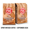 Two bags of FDC Fire Department Bar Coffee Glazed Maple Whiskey coffee with a brown liquid swirl design, shown on a white background with a black text banner at the bottom reading 'SPIRIT INFUSED COFFEE | SEPTEMBER 2026'.