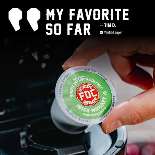 A hand inserts a FDC Spirit Infused Coffee K-Cup into a coffee maker. The top of the image features a quote graphic that reads ’MY FAVORITE SO FAR - TIM D.
