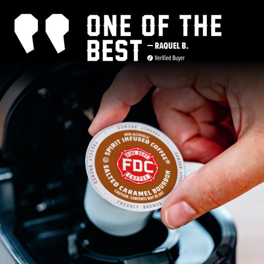 A hand holds a round FDC Spirit Infused Coffee K-cup pod above a coffee maker, with promotional text reading ’ONE OF THE BEST - RAQUEL B.’ on a dark background.