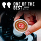 A hand holds a round FDC Spirit Infused Coffee K-cup pod above a coffee maker, with promotional text reading ’ONE OF THE BEST - RAQUEL B.’ on a dark background.