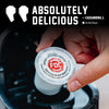 A hand holds a single FDC Vanilla Bean Powder coffee pod over a black coffee maker, with large text reading 'ABSOLUTELY DELICIOUS' and a verified buyer badge at the top.