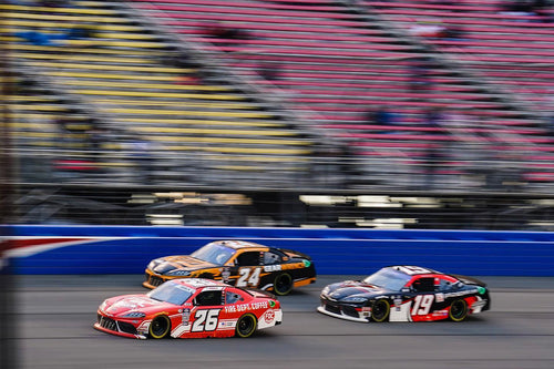 NASCAR race with Kaz Grala #26 car ahead of two other cars