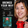 A promotional graphic for a coffee pod maker showing a smiling woman on the right holding a red mug, and product text plus a pod package illustration on the left. The text reads 'BREWED YOUR WAY' and 'Load, press start, and serve.