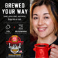 A promotional graphic for a coffee pod maker showing a smiling woman on the right holding a red coffee mug, and product text on the left. The text reads ’BREWED YOUR WAY’ and includes a skull illustration wearing a firefighter helmet with the brand FOC visible on the pod packaging graphic.