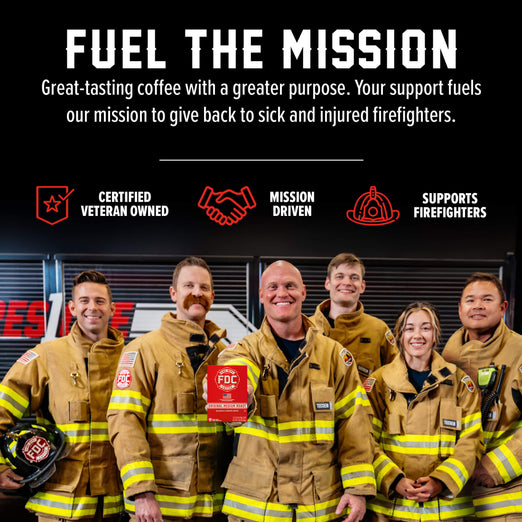 A group of firefighters in tan turnout jackets and helmets pose together in front of a dark fire station interior, with large promotional text above reading ’FUEL THE MISSION’ and supporting callouts including ’Certified Veteran Owned,’ ’Mission Driven,’ and ’Supports Firefighters.’.