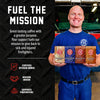 Smiling man in a blue Fire Department Coffee uniform holds four Spirit Infused Coffee bags in front of a fire truck. “Fuel the Mission” text highlights the certified veteran-owned company’s support for sick and injured firefighters.