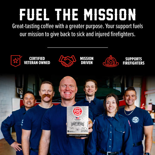 A group of smiling firefighters in navy uniforms hold a box of FDC Vanilla Bean Coffee in a garage setting. The top of the image features a black banner with white text reading ’FUEL THE MISSION’ and red icons for ’CERTIFIED VETERAN OWNED’, ’MISSION DRIVEN’, and ’SUPPORTS FIREFIGHTERS’.