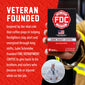 A hand holds a box of FDC Fire Department Coffee Dark Roast against a red promotional graphic with white text about the brand being inspired by a veteran firefighter named Luke Schneider. A small circular photo of Luke in a sailor uniform appears at the bottom right.