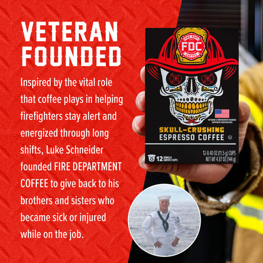 A hand holds a box of Fire Department Coffee ’Skull-Crushing Espresso Coffee’ against a red textured background with white text reading ’VETERAN FOUNDED’ and a short descriptive blurb. The box features a skull wearing a firefighter helmet, and a small circular inset photo shows a man in a white sailor uniform.