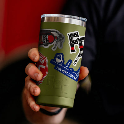 Green tumbler with Fire Department Coffee branding and related branded stickers on a white background.